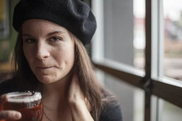 Mladá žena pije inda světlé pivo — Stock fotografie