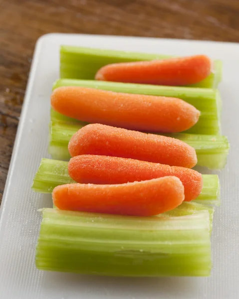 Celery Stalks and Carrots on White Plastic Cutting Boardl (dalam bahasa Inggris) — Stok Foto