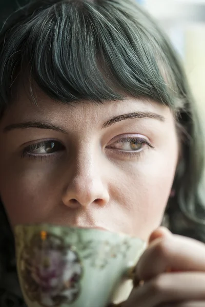 Młoda kobieta z filiżanki herbaty antyczne — Zdjęcie stockowe