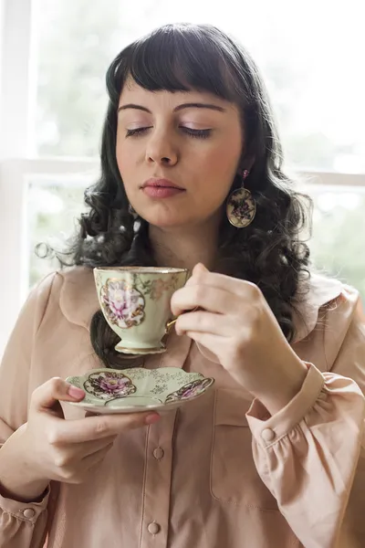 Mladá žena s starožitný tea cup — Stock fotografie