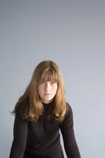 Foto de una chica contra una pared azul . —  Fotos de Stock