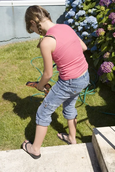 Stock Photo of a Girl Filling Up a Squirt Gun — Stock Photo, Image