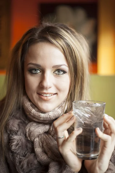 Молодая женщина с красивыми голубыми глазами пьет воду — стоковое фото