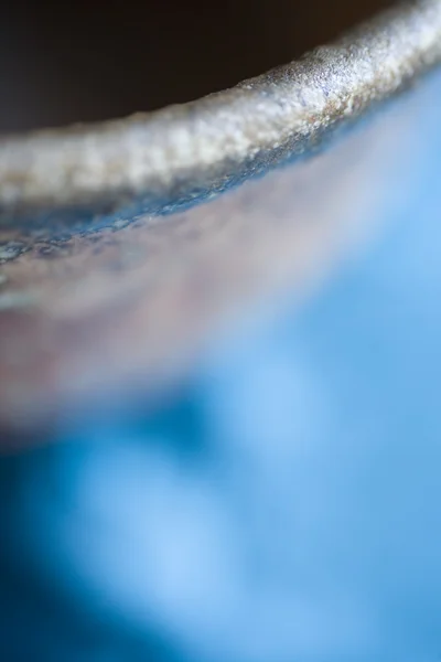 Foto stock de uma tigela de cerâmica em fundo azul — Fotografia de Stock