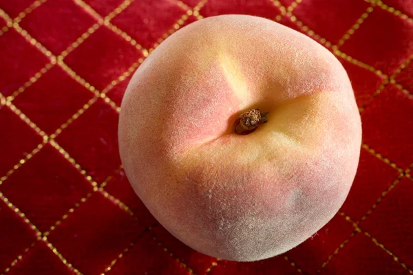 Organically Grown Peach on Red Tablecloth — Stock Photo, Image