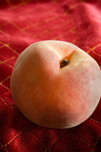 Organically Grown Peach on Red Tablecloth — Stock Photo, Image