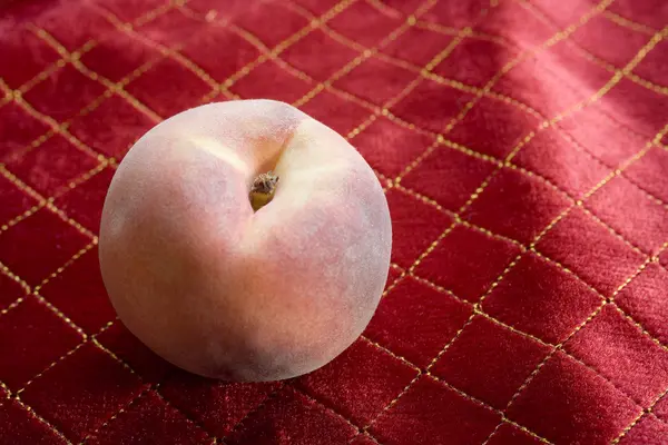 Organically Grown Peach on Red Tablecloth — Stock Photo, Image