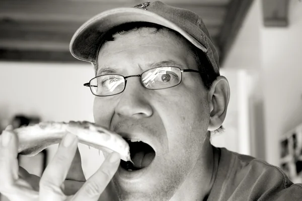 男子吃意大利辣香肠比萨饼 — 图库照片