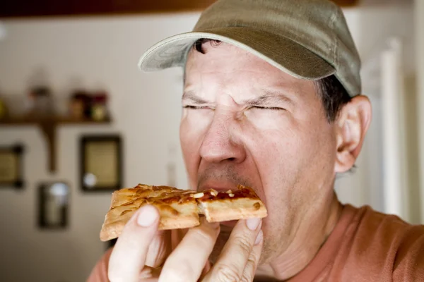 Man äta äckliga pepperoni pizza — Stockfoto