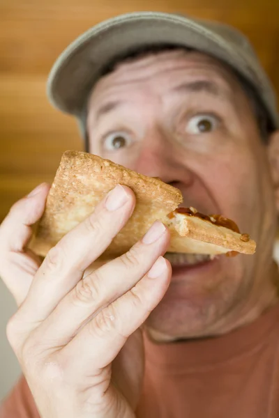 Verängstigter Mann isst Pfefferoni-Pizza — Stockfoto