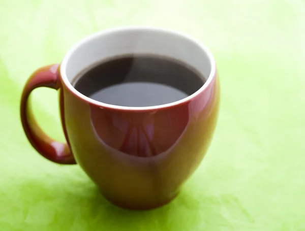 Yeşil zemin üzerine kırmızı kahve fincanı — Stok fotoğraf