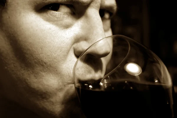 Приваблива, серйозна людина п'є вино — стокове фото