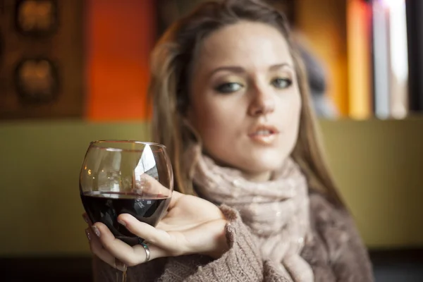 Mulher jovem com belos olhos azuis bebendo vinho tinto — Fotografia de Stock