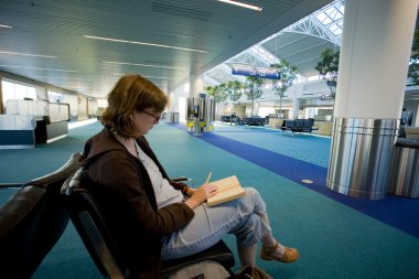 kadın bir boş Havaalanı lounge okuma