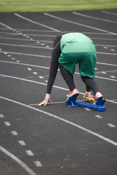 Girl track ster krijgen in de startblokken — Stockfoto