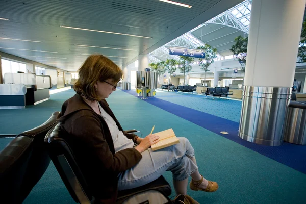 kadın bir boş Havaalanı lounge okuma