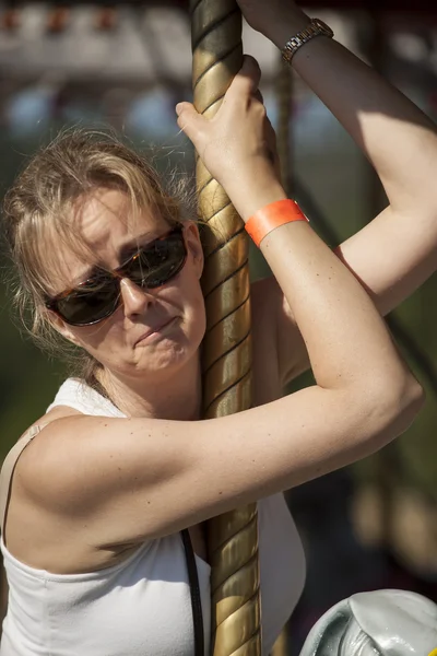 Bella bionda madre stanca di cavalcare la giostra — Foto Stock