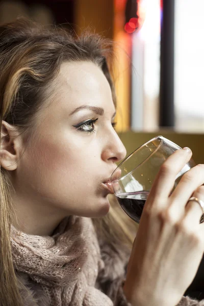 Mujer joven con hermosos ojos azules bebiendo vino tinto —  Fotos de Stock