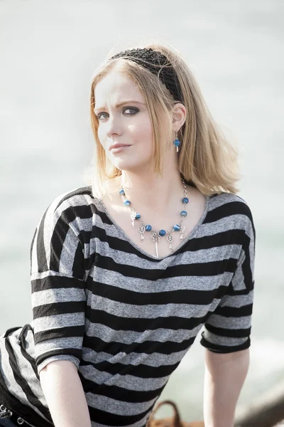 Jonge vrouw met mooie blauwe ogen op het strand — Stockfoto