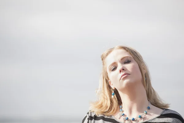 Mulher jovem com belos olhos azuis na praia — Fotografia de Stock