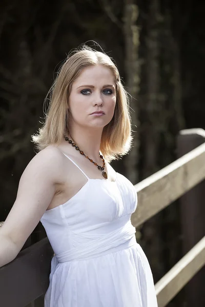 Mooie jonge blonde vrouw in een witte jurk — Stockfoto