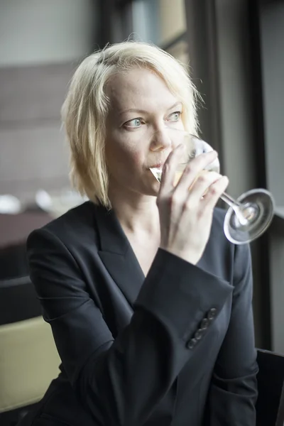 Femme blonde avec de beaux yeux bleus Boire un verre de blanc Wi — Photo