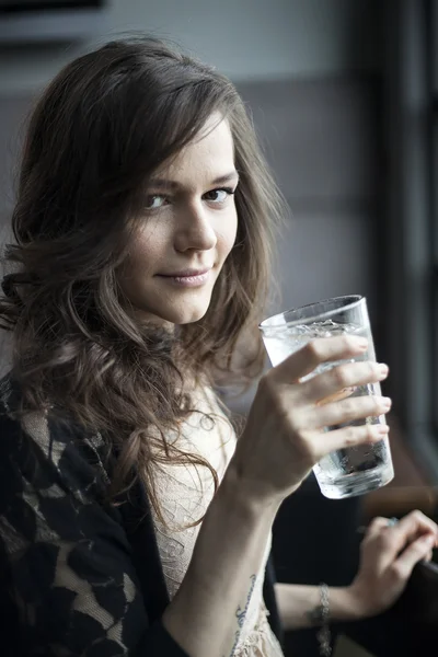 Giovane donna che beve un bicchiere di acqua ghiacciata — Foto Stock