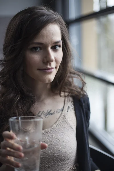 Mujer joven bebiendo un vaso de cerveza de agua helada — Foto de Stock