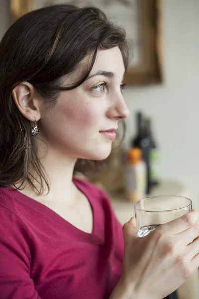 Молодая женщина с красивыми зелеными глазами пьет воду — стоковое фото