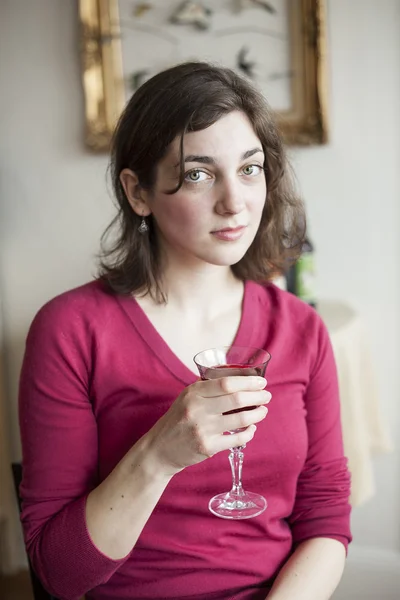 Mulher jovem com belos olhos verdes bebendo vinho — Fotografia de Stock