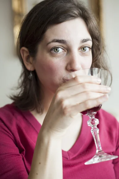 Mladá žena s krásné zelené oči, pití vína — Stock fotografie