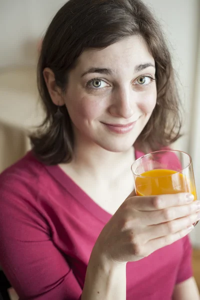 年轻女子美丽的绿眼睛喝芒果汁 — 图库照片