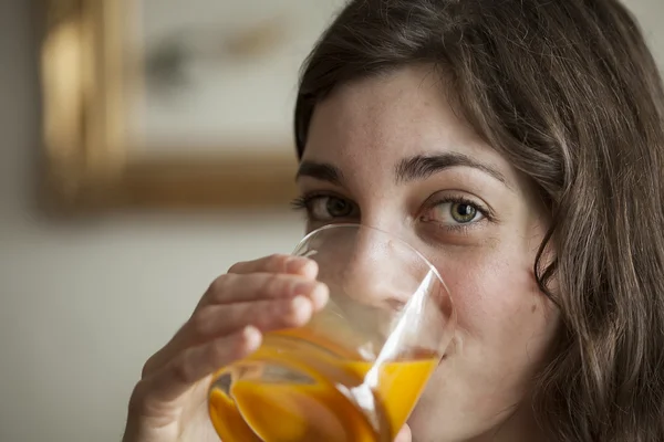 Mujer joven con hermosos ojos verdes bebiendo jugo de mango —  Fotos de Stock