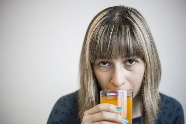Mujer joven bebiendo jugo de mango —  Fotos de Stock