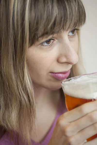 Młoda kobieta pije kubek piwa — Zdjęcie stockowe