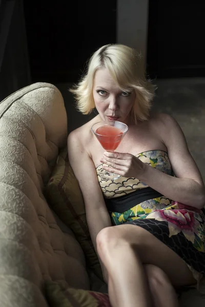 Blonďatá žena pít růžové martini — Stock fotografie