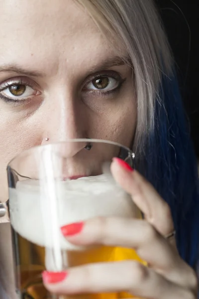 Belle jeune femme avec des cheveux bleus boire de la bière — Photo