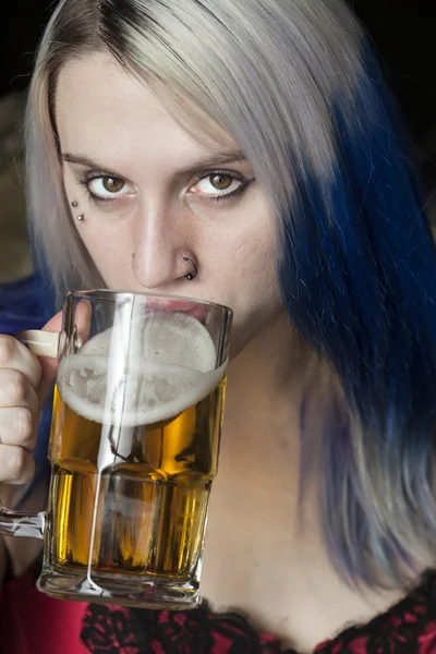 Mooie jonge vrouw met blauwe haar bier drinken — Stockfoto