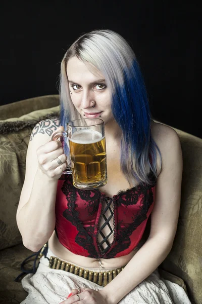 Belle jeune femme avec des cheveux bleus boire de la bière — Photo