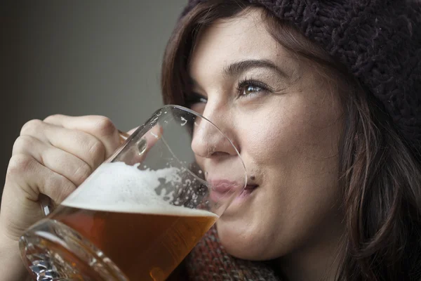 Hermosa mujer joven en bufanda de punto y sombrero bebe cerveza —  Fotos de Stock