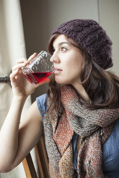Bella giovane donna che beve vetro di succo di mirtillo rosso — Foto Stock
