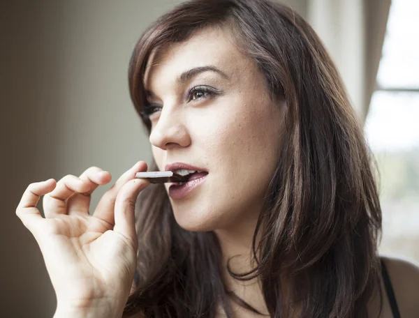 güzel bir genç kadın koyu çikolata yiyor