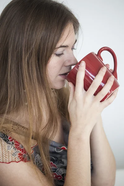 Mujer joven con hermosos ojos verdes con taza de café rojo —  Fotos de Stock