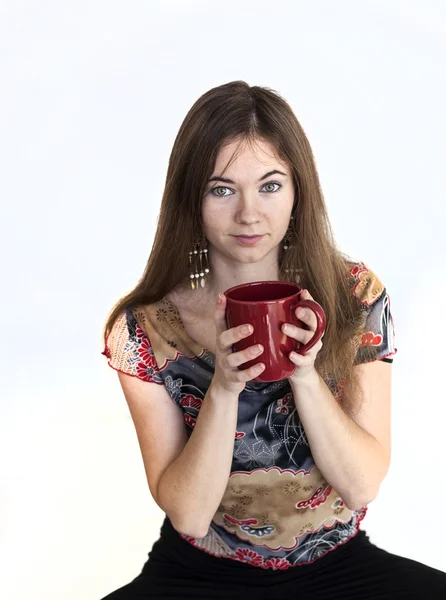 Giovane donna con bellissimi occhi verdi con tazza di caffè rosso — Foto Stock