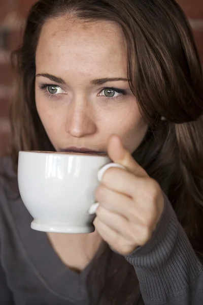 Giovane donna con bellissimi occhi verdi con tazza di caffè bianco — Foto Stock