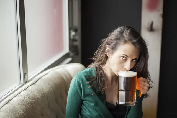 Hermosa mujer joven sosteniendo taza de cerveza — Foto de Stock