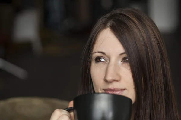 Mooie jonge vrouw met bruin haar en ogen houden zwarte cof — Stockfoto