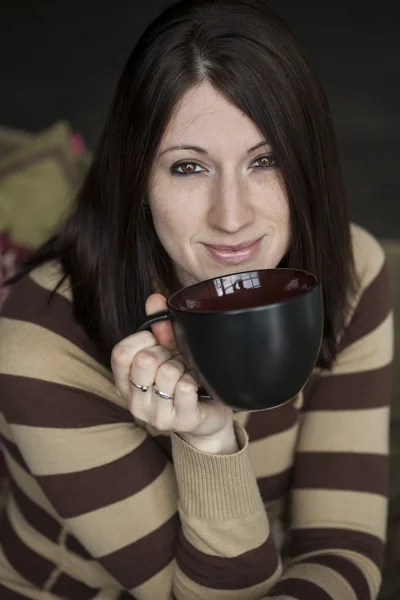 Piękna młoda kobieta z brązowe włosy i oczy trzymając czarny cof — Zdjęcie stockowe