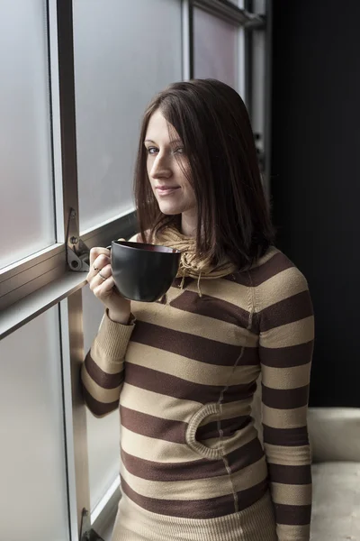 Vrouw met een zwarte koffiekop. — Stockfoto