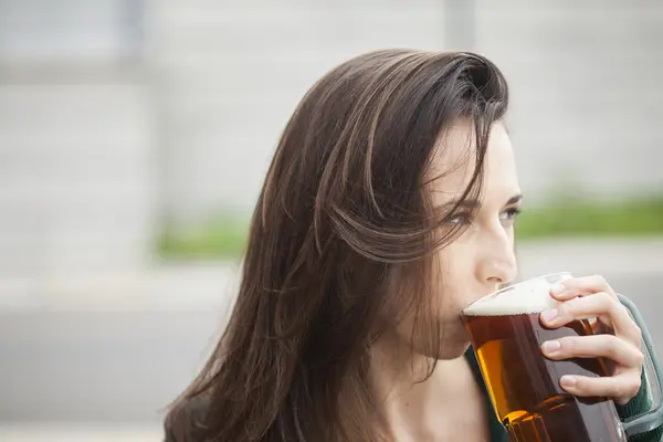 Hermosa mujer joven sosteniendo taza de cerveza — Foto de Stock